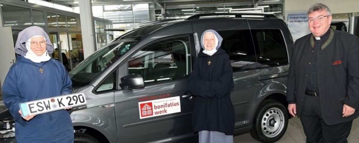 Sr. Karina (v. l.), Sr. Marie Ange, Monsignore Georg Austen vor dem neuen Caddy